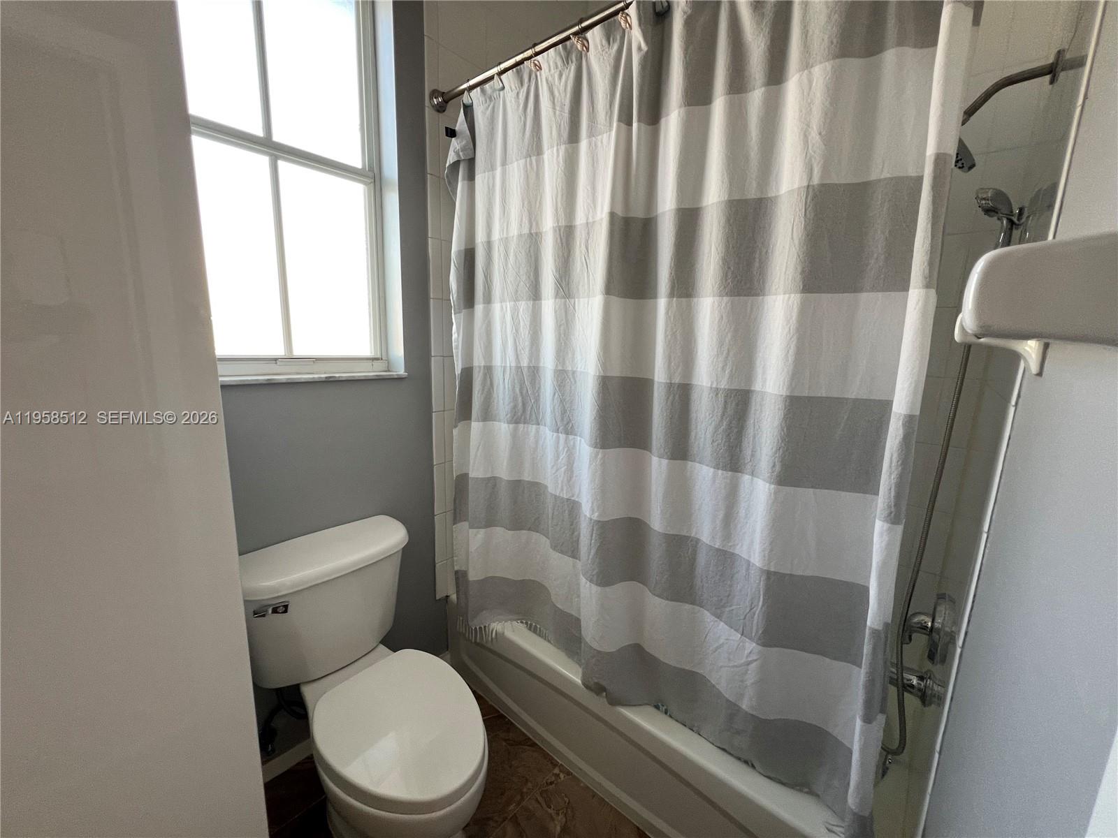 8001 West 36th Avenue, Unit 1 Hialeah, FL 33018 - Photo 44 of 48 a white toilet sitting next to a bathroom sink