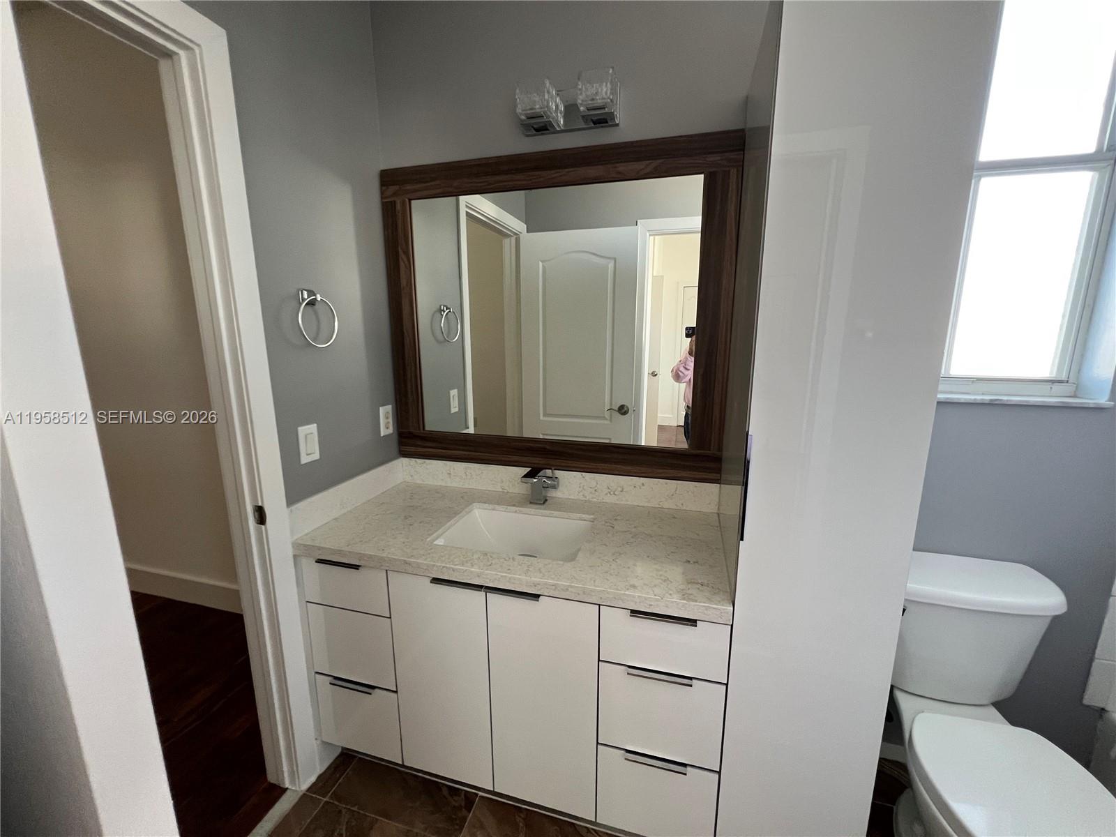 8001 West 36th Avenue, Unit 1 Hialeah, FL 33018 - Photo 46 of 48 a bathroom with a toilet sink and mirror