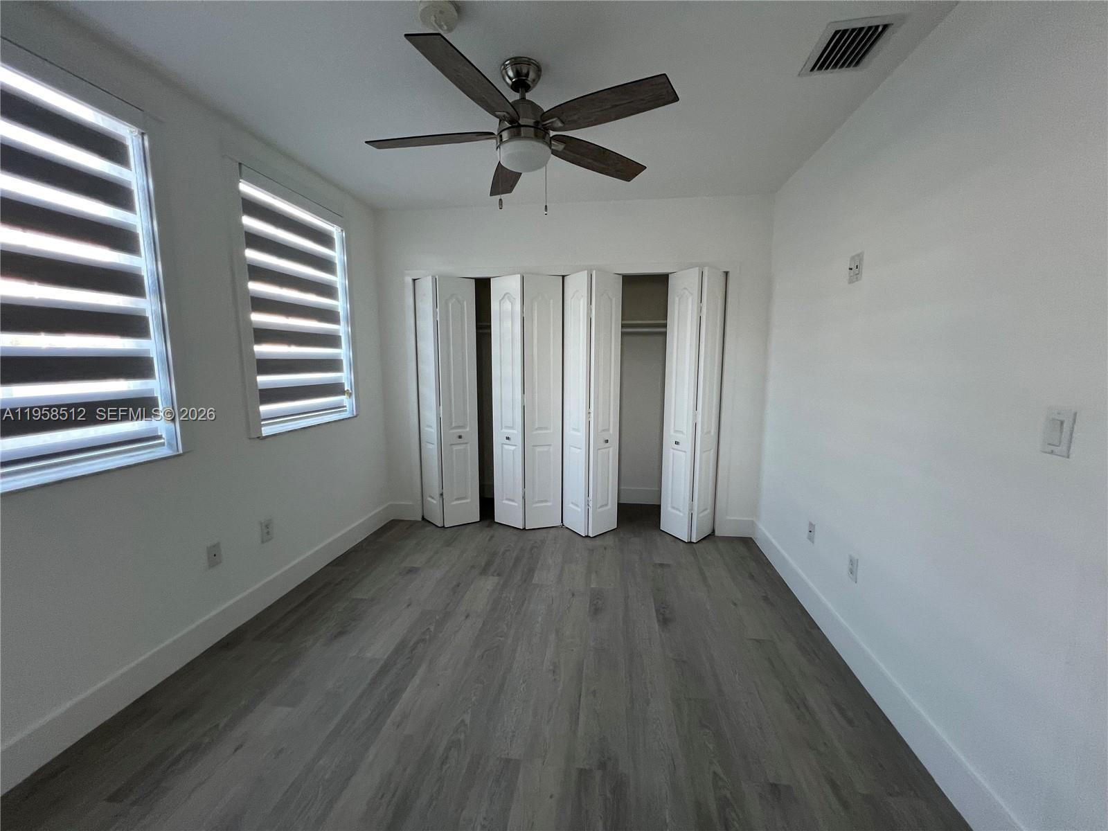 8001 West 36th Avenue, Unit 1 Hialeah, FL 33018 - Photo 10 of 48 wooden floor in an empty room with a window