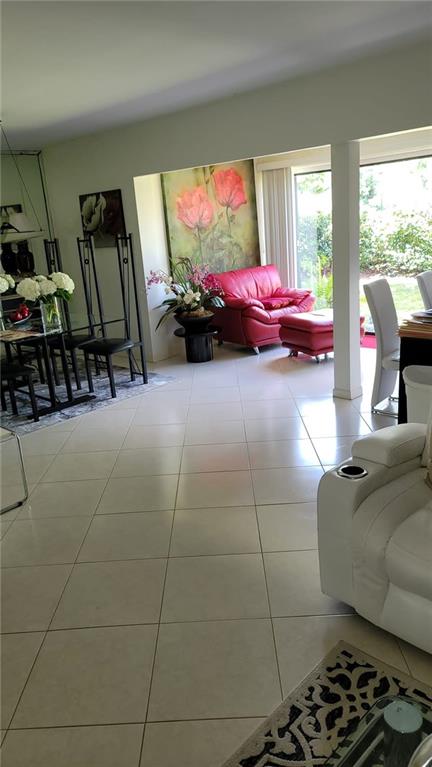 6574 Burning Wood Drive, Unit 101 Boca Raton, FL 33433 - Photo 20 of 25 a living room with furniture a window and a flat screen tv