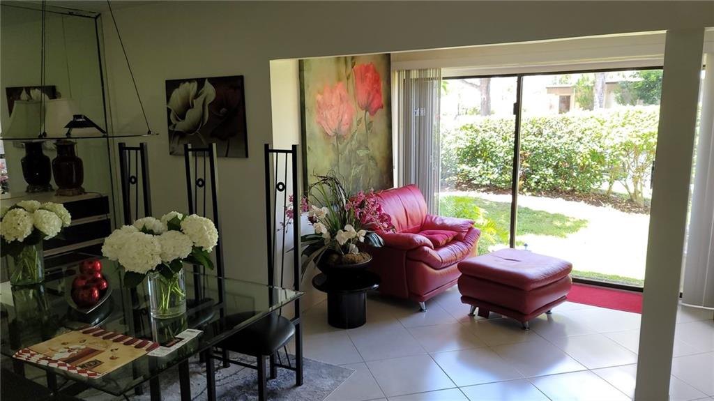 6574 Burning Wood Drive, Unit 101 Boca Raton, FL 33433 - Photo 2 of 25 a living room with furniture and a floor to ceiling window