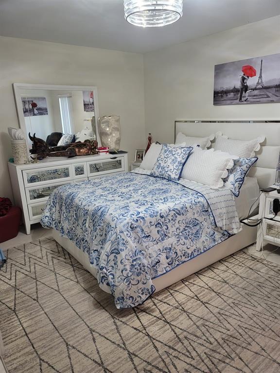 6574 Burning Wood Drive, Unit 101 Boca Raton, FL 33433 - Photo 23 of 25 a bedroom with a bed and a dresser