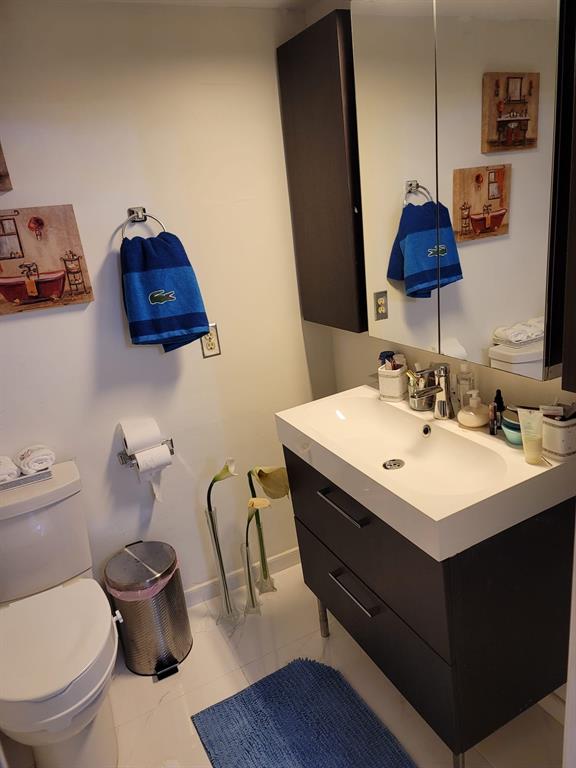 6574 Burning Wood Drive, Unit 101 Boca Raton, FL 33433 - Photo 25 of 25 a bathroom with a toilet a sink and mirror