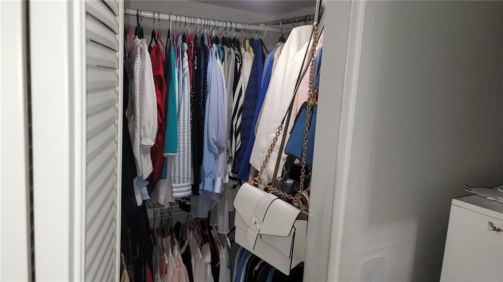 6574 Burning Wood Drive, Unit 101 Boca Raton, FL 33433 - Photo 6 of 25 a view of walk in closet with clothes and shoes