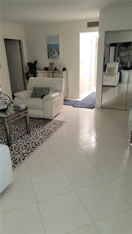 6574 Burning Wood Drive, Unit 101 Boca Raton, FL 33433 - Photo 7 of 25 a living room with a couch and a potted plant on the counter