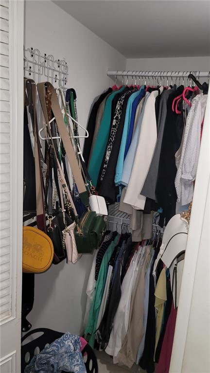 6574 Burning Wood Drive, Unit 101 Boca Raton, FL 33433 - Photo 8 of 25 a view of walk in closet with clothes and shoes
