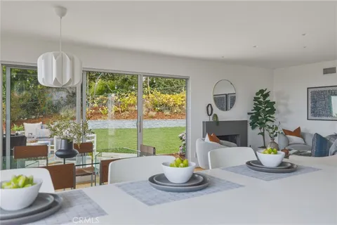a dining room with furniture a rug and a floor to ceiling window