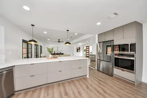 a kitchen with stainless steel appliances kitchen island granite countertop a refrigerator and a stove top oven