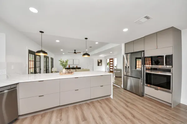 a kitchen with stainless steel appliances kitchen island granite countertop a refrigerator and a stove top oven
