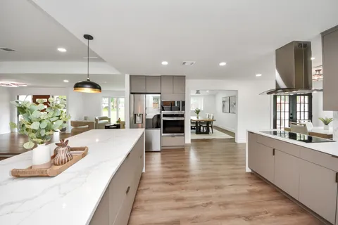 a view of a kitchen with kitchen island stainless steel appliances refrigerator stove microwave and cabinets