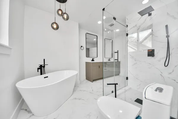 a bathroom with a sink a toilet and shower