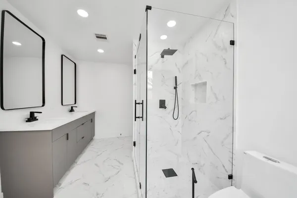 a bathroom with a double vanity sink mirror double and shower