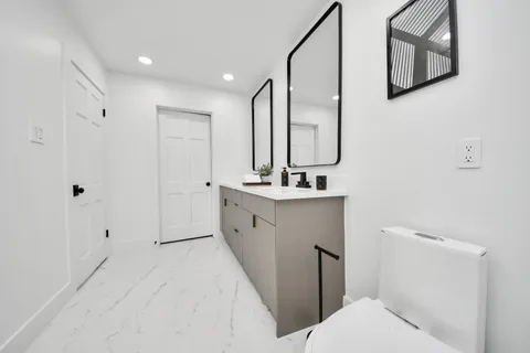 a bathroom with a toilet sink and mirror