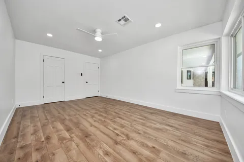 a view of empty room with wooden floor