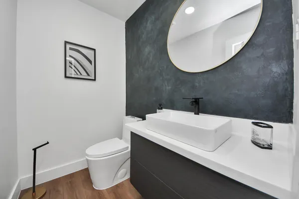 a bathroom with a sink a toilet and mirror