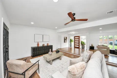a living room with furniture and a wooden floor