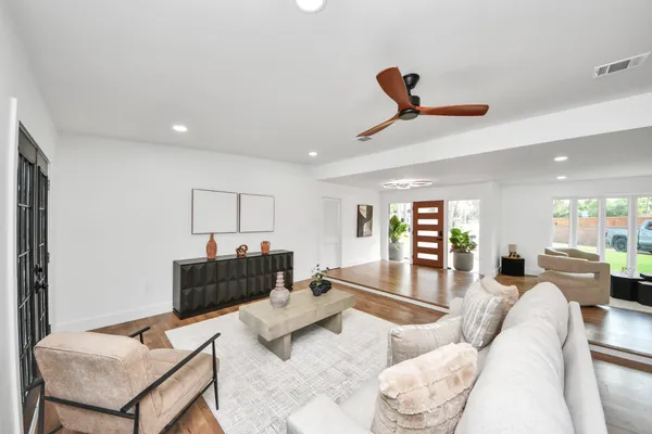 a living room with furniture and a wooden floor