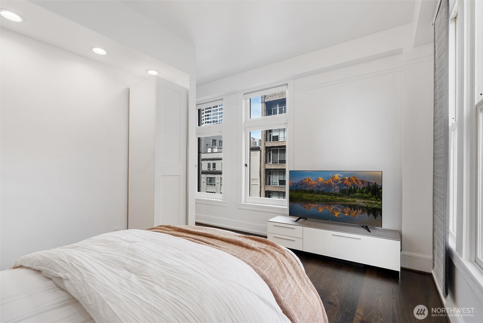 1519 3rd Avenue, Unit 501 Seattle, WA 98101 - Photo 28 of 37 a bedroom with a bed a flat screen tv and a window