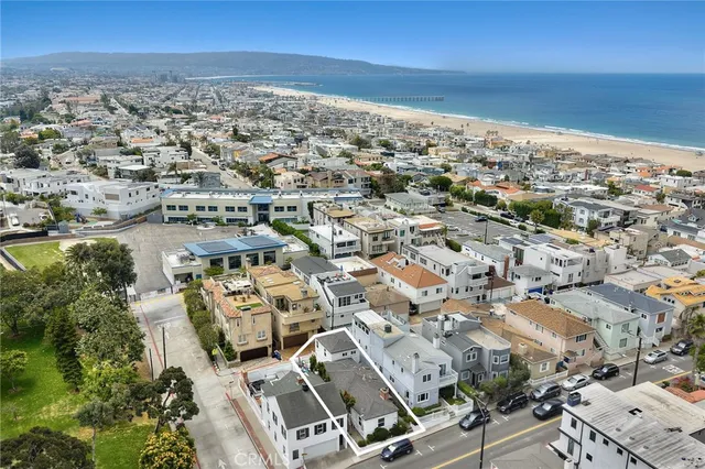 an aerial view of a city with ocean view in back