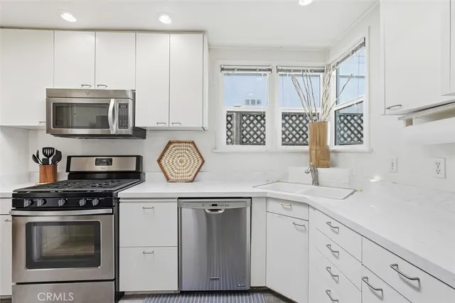 a kitchen with cabinets stainless steel appliances and a sink