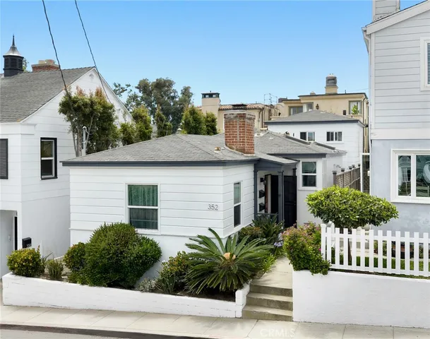 a front view of a house with plants and garage