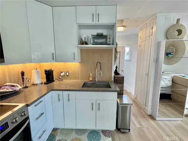 a kitchen with white cabinets and sink