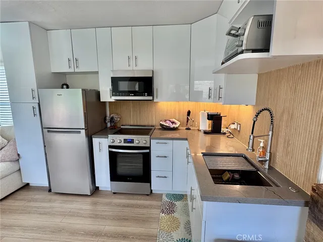 a kitchen with white cabinets and stainless steel appliances
