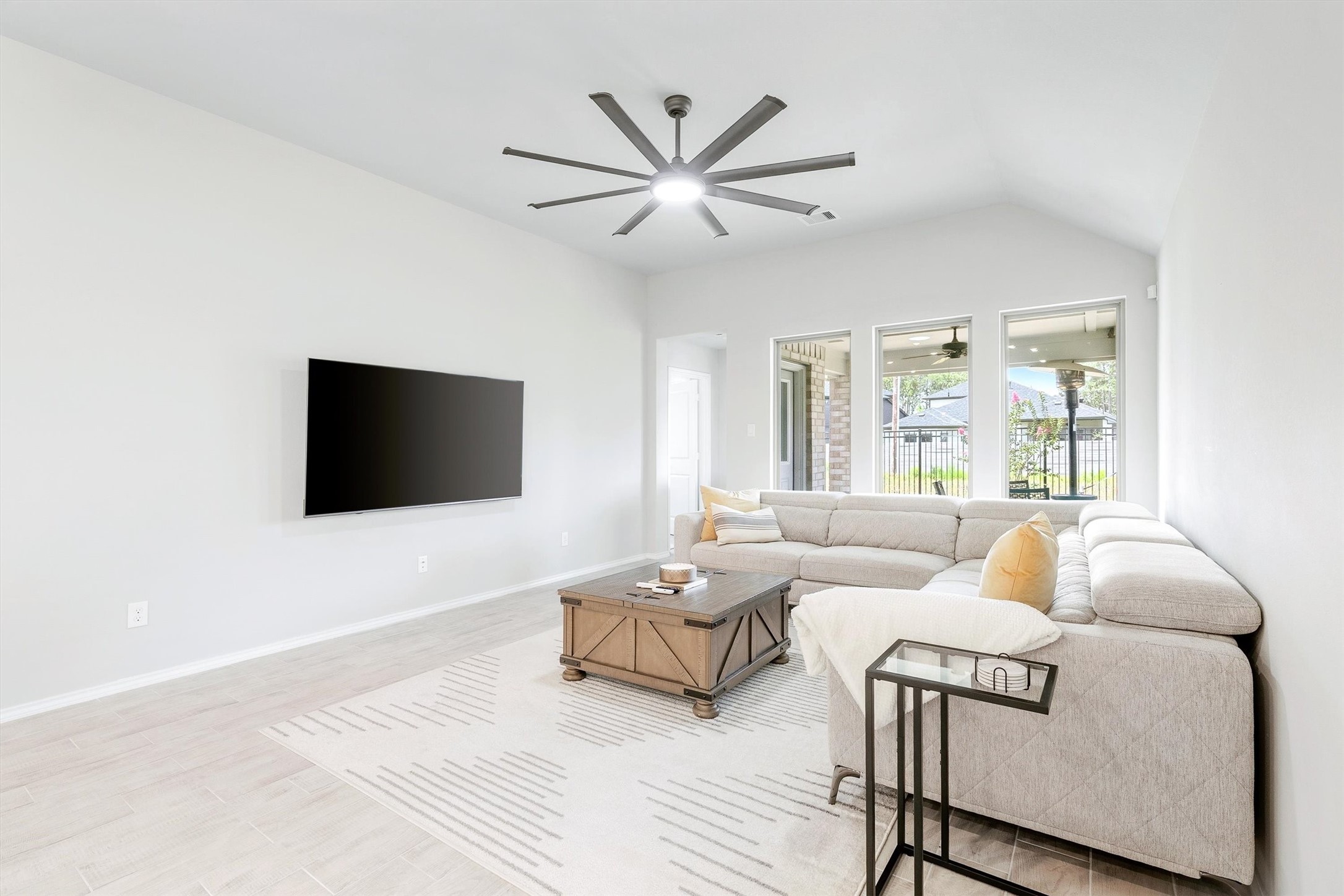 17270 Wild Watermelon Way Conroe, TX 77302 - Photo 4 of 28 The family room features vaulted ceilings, a upgraded ceiling fan, and a wall of windows that pulls in natural light and a peek at the covered patio beyond.