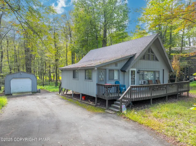 a view of house with swimming pool and a yard