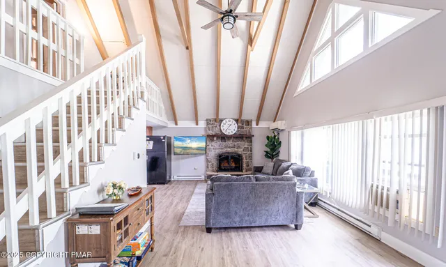 a dining room with stainless steel appliances a refrigerator a stove a kitchen island with chairs and wooden floor