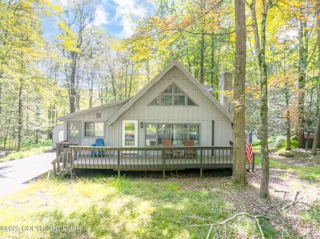 a view of a house with a yard wooden fence and a tree