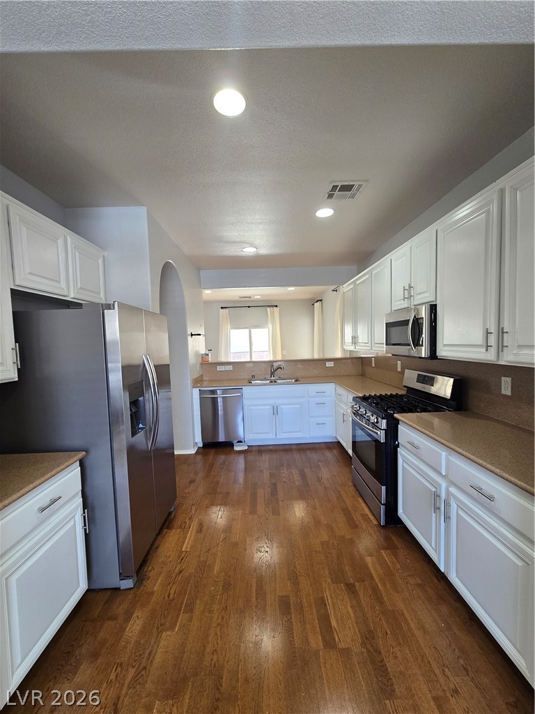 1049 Garnet Ridge Court Las Vegas, NV 89123 - Photo 11 of 39 Kitchen featuring white cabinets, stainless steel appliances, dark wood-type flooring, and recessed lighting