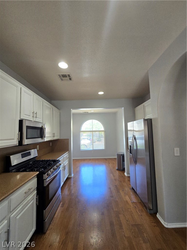 1049 Garnet Ridge Court Las Vegas, NV 89123 - Photo 13 of 39 Kitchen with stainless steel appliances, white cabinets, dark wood finished floors, recessed lighting, and light stone countertops