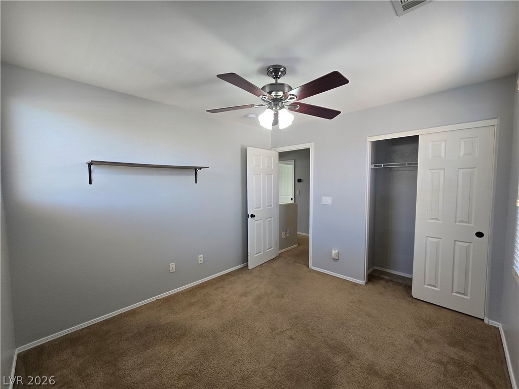 1049 Garnet Ridge Court Las Vegas, NV 89123 - Photo 32 of 39 Unfurnished bedroom with dark colored carpet, a closet, and ceiling fan