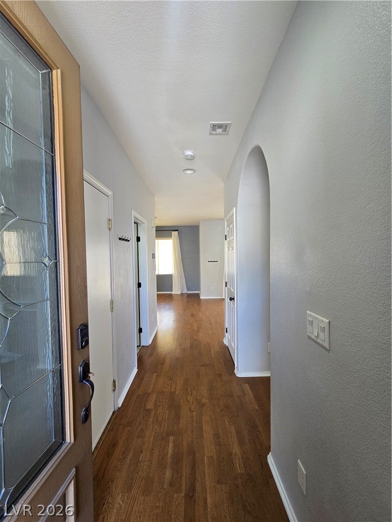 1049 Garnet Ridge Court Las Vegas, NV 89123 - Photo 4 of 39 Hallway featuring arched walkways, dark wood finished floors, and a textured wall
