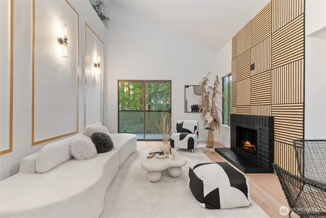 a living room with furniture a fireplace and a large window