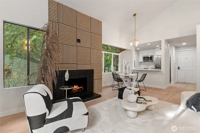 a living room with furniture a fireplace and a floor to ceiling window
