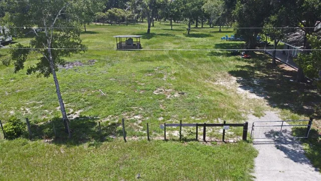 an aerial view of residential house with outdoor space and trees all around