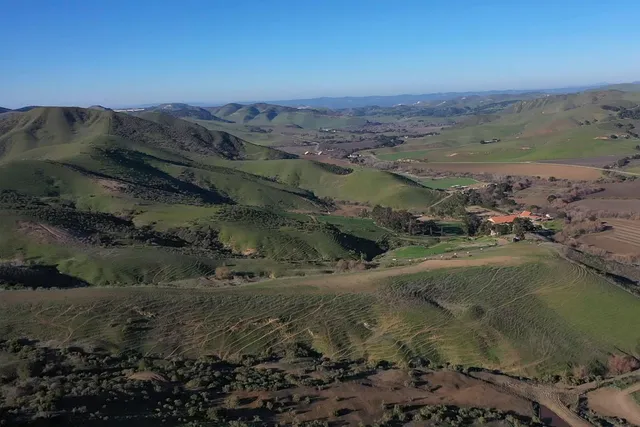 a view of a lush green hillside and houses