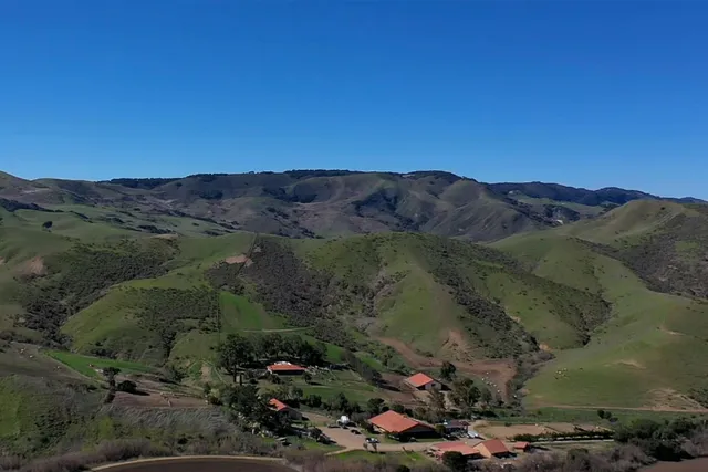 a view of a lush green hillside and houses