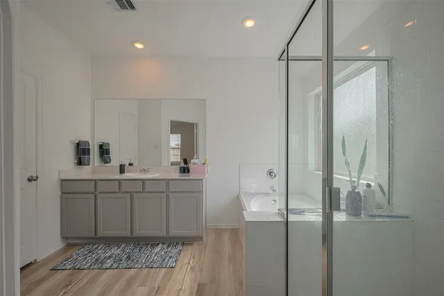 a spacious bathroom with a shower sink and mirror