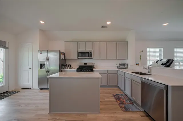 a kitchen with cabinets and stainless steel appliances