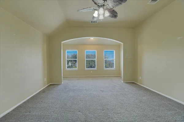 an empty room with chandelier fan