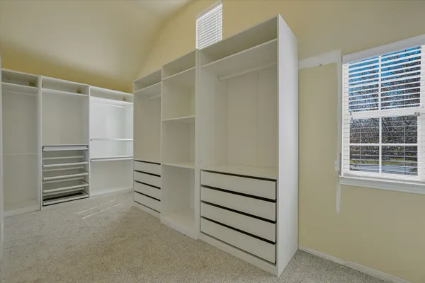 a view of walk in closet with empty racks