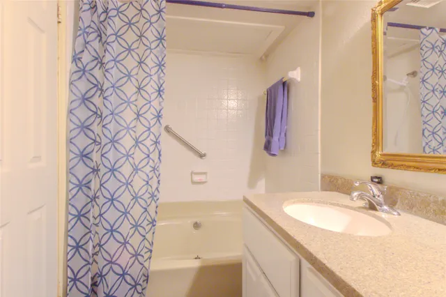 a bathroom with a granite countertop sink a mirror and a shower