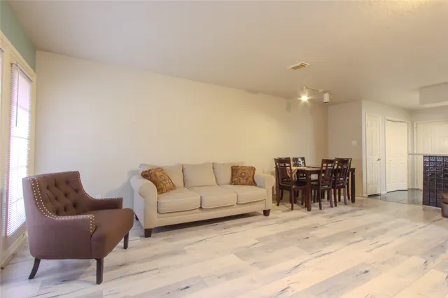 a living room with furniture and a dining table with kitchen view