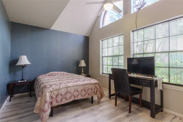 a bedroom with a bed table and a window