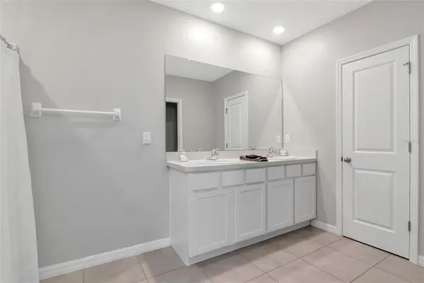 a bathroom with a double vanity sink and a mirror