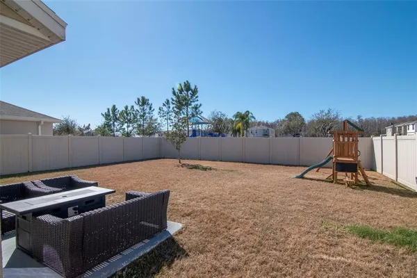 a backyard of a house with table and chairs