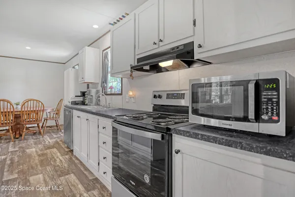 a kitchen with stainless steel appliances granite countertop a stove a sink and a microwave